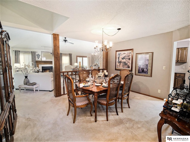 dining area featuring ceiling fan with notable chandelier, lofted ceiling, a textured ceiling, and light carpet