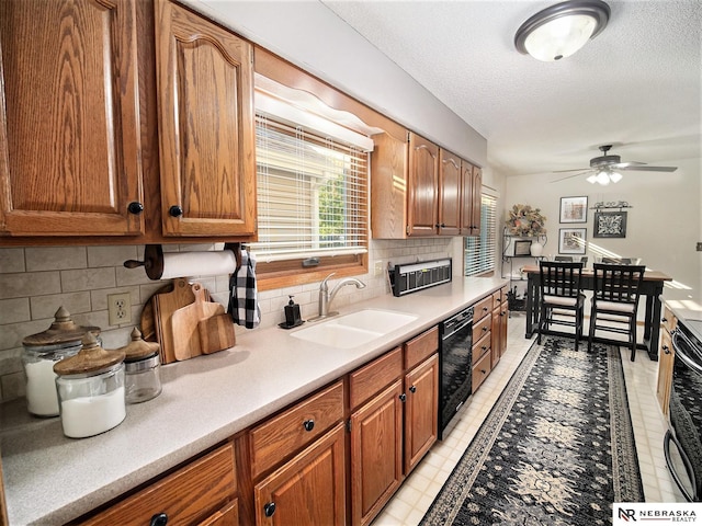 kitchen featuring ceiling fan, dishwasher, decorative backsplash, and sink