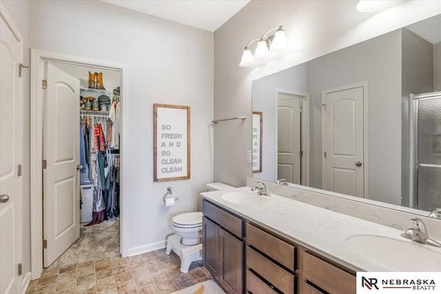 bathroom featuring toilet, vanity, and walk in shower