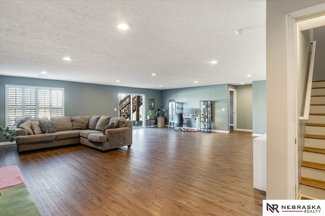 unfurnished living room featuring wood-type flooring and a textured ceiling