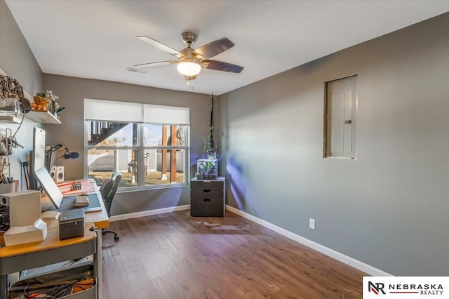 home office with electric panel, ceiling fan, and dark hardwood / wood-style floors