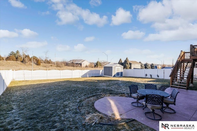 view of yard with a storage shed and a patio