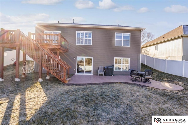 back of house featuring a patio area, a lawn, and a wooden deck