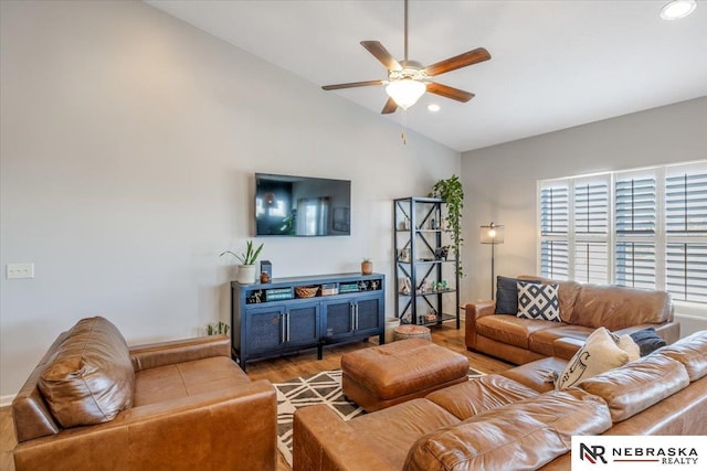 living room featuring ceiling fan, lofted ceiling, and wood-type flooring