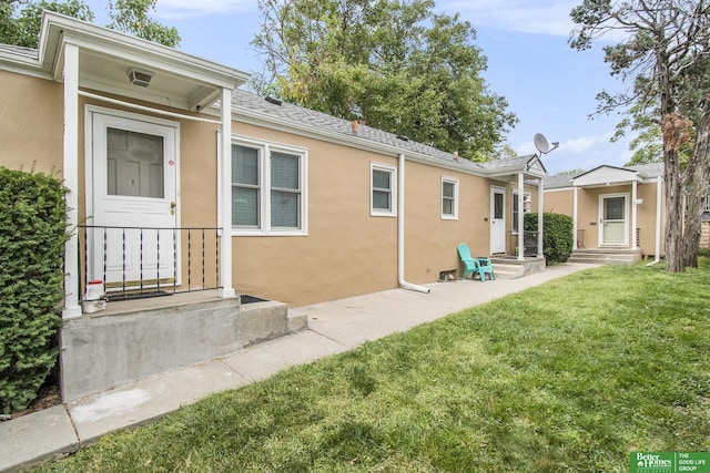 rear view of property featuring a lawn