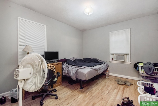 bedroom with light hardwood / wood-style floors and cooling unit