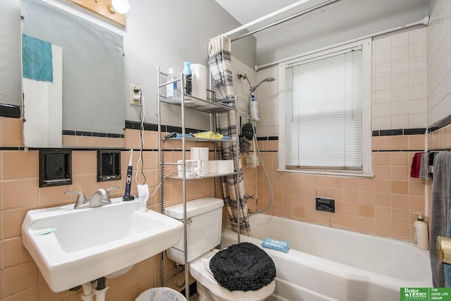 full bathroom featuring tile walls, shower / bath combo, sink, and toilet