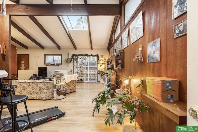 living room featuring wooden walls, hardwood / wood-style flooring, and beamed ceiling