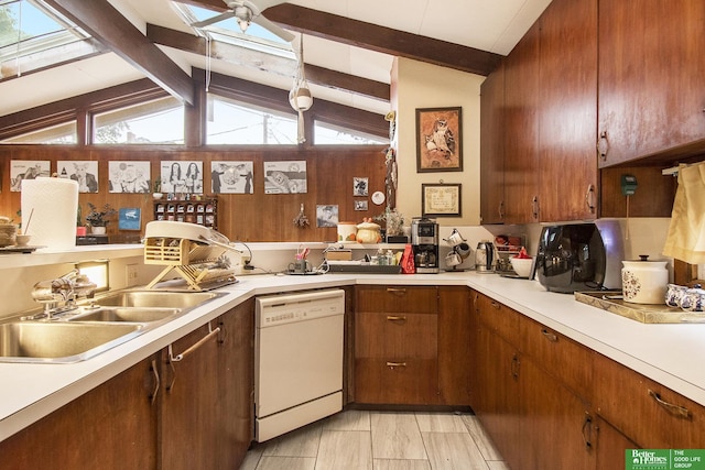 kitchen with sink, lofted ceiling with skylight, and dishwasher