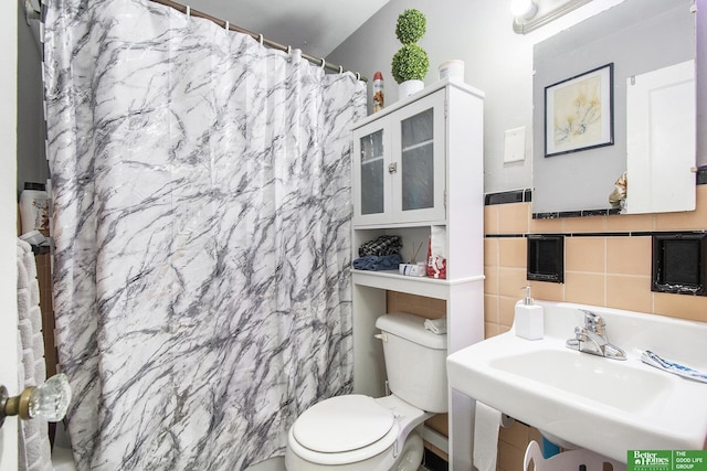 bathroom with sink, a shower with shower curtain, tile walls, and toilet