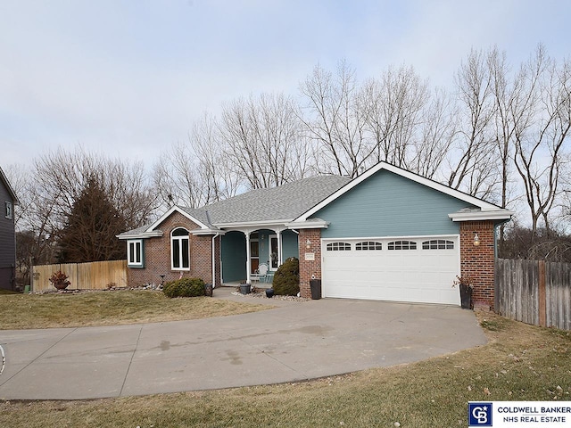 single story home featuring covered porch, a front lawn, and a garage