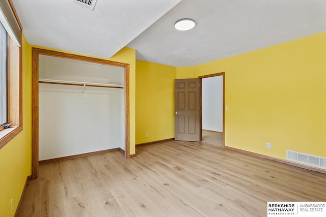 unfurnished bedroom featuring a closet and light hardwood / wood-style flooring