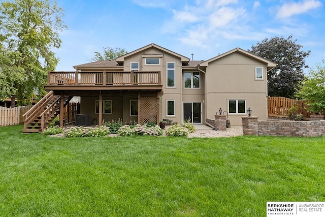 rear view of house with central air condition unit, a deck, and a yard