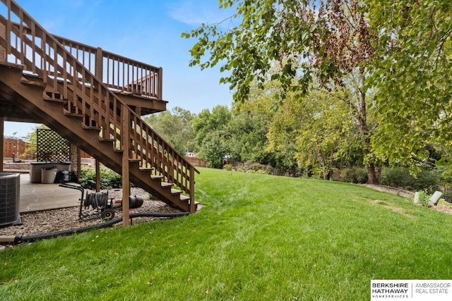 view of yard with central AC and a patio