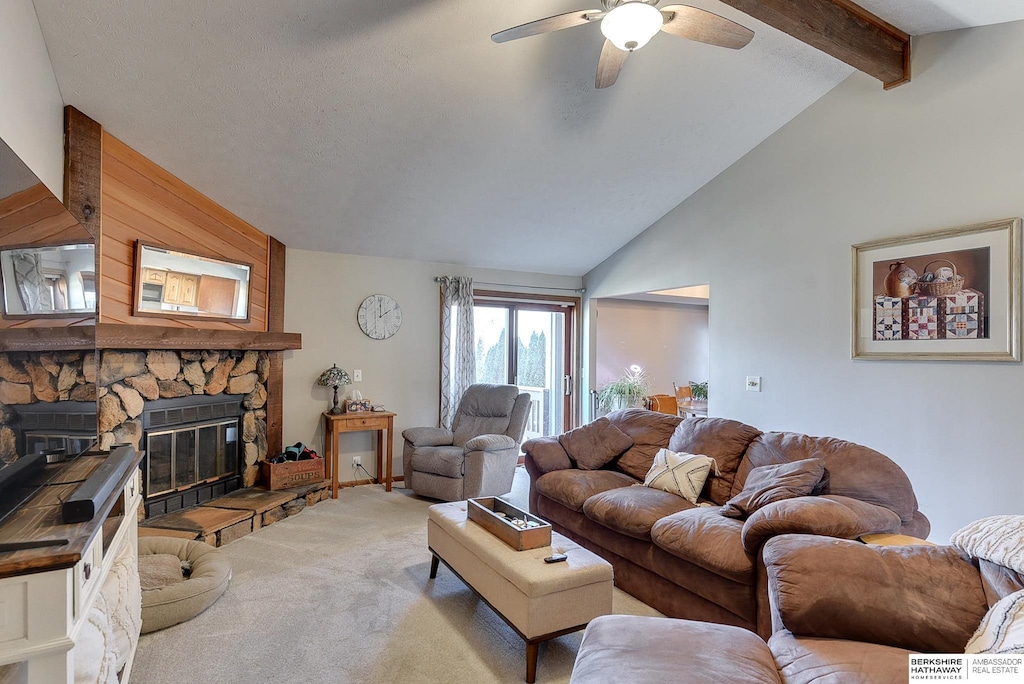 carpeted living room featuring ceiling fan, lofted ceiling with beams, and a fireplace