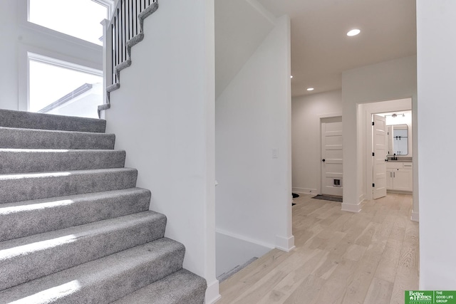 stairs featuring hardwood / wood-style floors