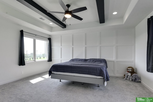 carpeted bedroom with ceiling fan and beamed ceiling