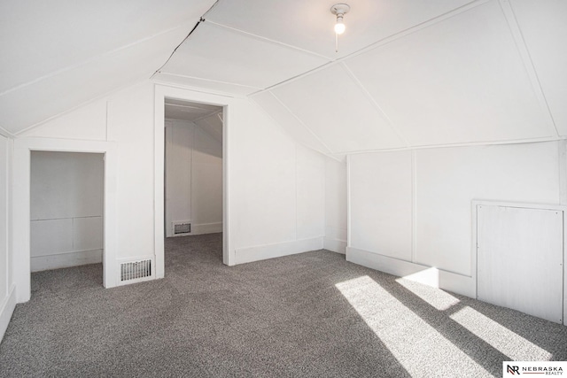 additional living space featuring lofted ceiling and carpet flooring