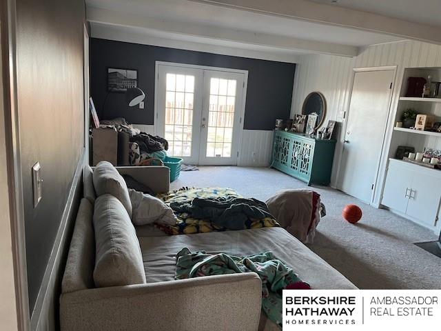 living room featuring carpet flooring, french doors, and beamed ceiling