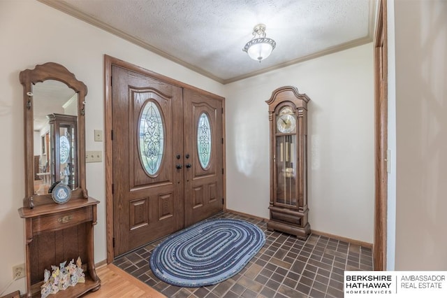 foyer with a textured ceiling and ornamental molding