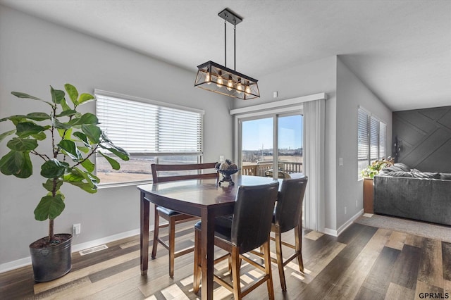 dining room with hardwood / wood-style flooring and a notable chandelier