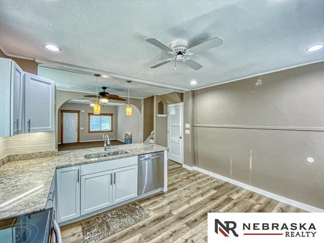 kitchen featuring stainless steel dishwasher, white cabinetry, sink, and light hardwood / wood-style flooring