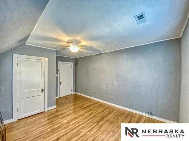 unfurnished bedroom with lofted ceiling, ceiling fan, and hardwood / wood-style floors