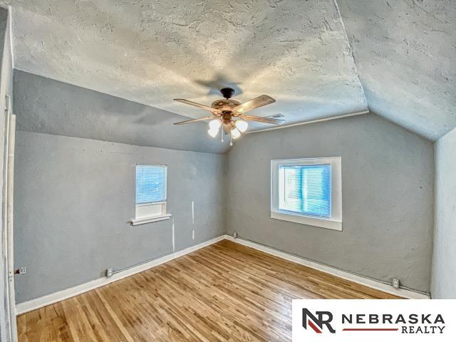 bonus room with vaulted ceiling, wood-type flooring, and plenty of natural light