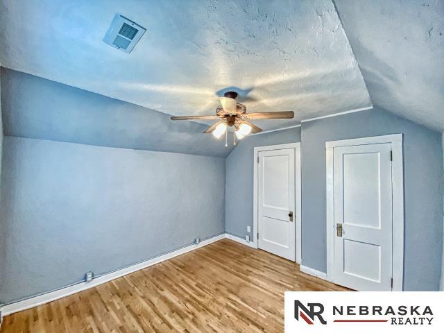 bonus room with ceiling fan, light hardwood / wood-style flooring, and vaulted ceiling