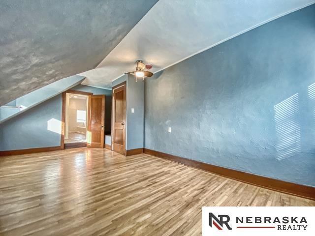 bonus room with vaulted ceiling, ceiling fan, and hardwood / wood-style flooring