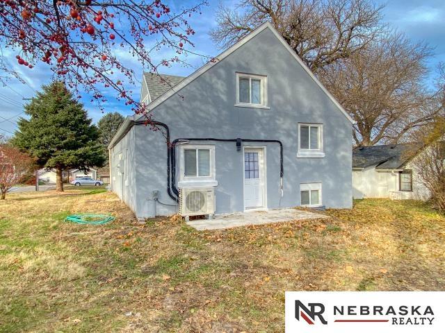 back of house featuring ac unit and a lawn