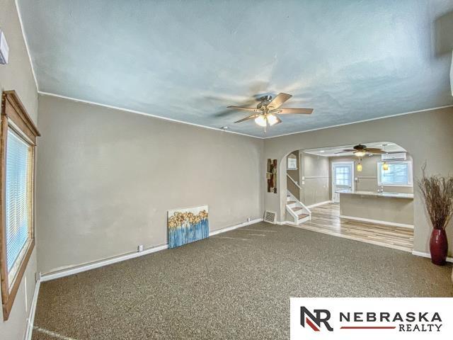 carpeted spare room with ceiling fan