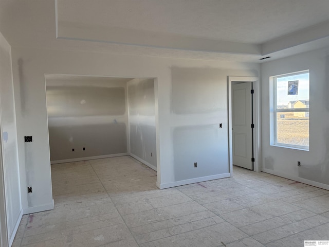 unfurnished room with baseboards