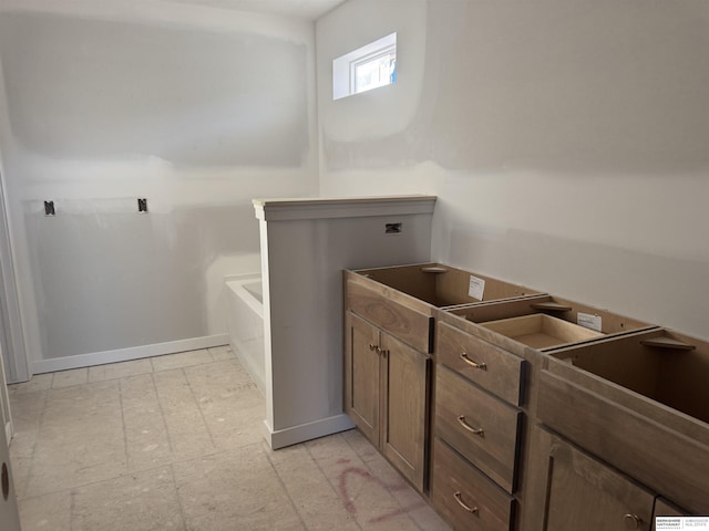 bathroom with tile patterned floors, baseboards, and a bathtub