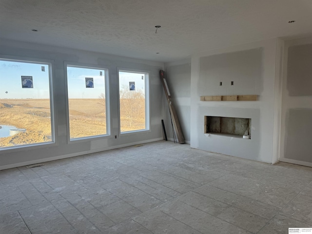 unfurnished living room with a fireplace, baseboards, and a textured ceiling