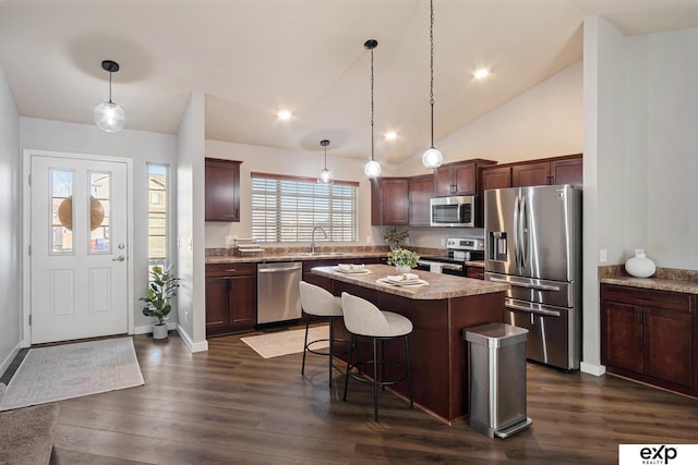 kitchen with sink, a kitchen island, decorative light fixtures, and appliances with stainless steel finishes