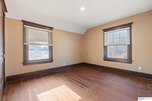 unfurnished room featuring dark hardwood / wood-style flooring and lofted ceiling