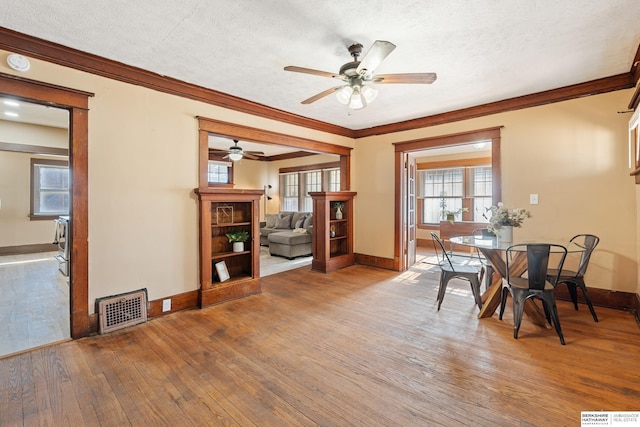 dining space featuring ornamental molding, a textured ceiling, ceiling fan, and hardwood / wood-style floors