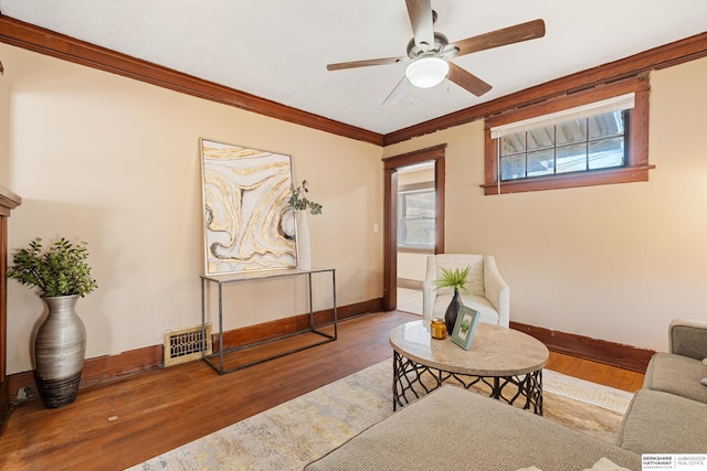 living room featuring ceiling fan, hardwood / wood-style flooring, and crown molding