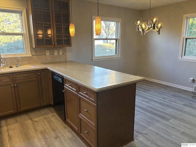 kitchen with sink, black dishwasher, light hardwood / wood-style flooring, and kitchen peninsula