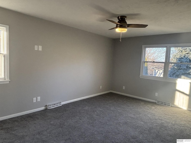 spare room with dark colored carpet and ceiling fan