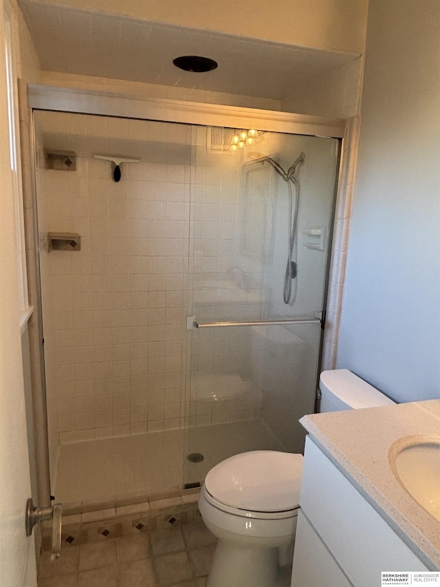 bathroom with tile patterned flooring, an enclosed shower, vanity, and toilet