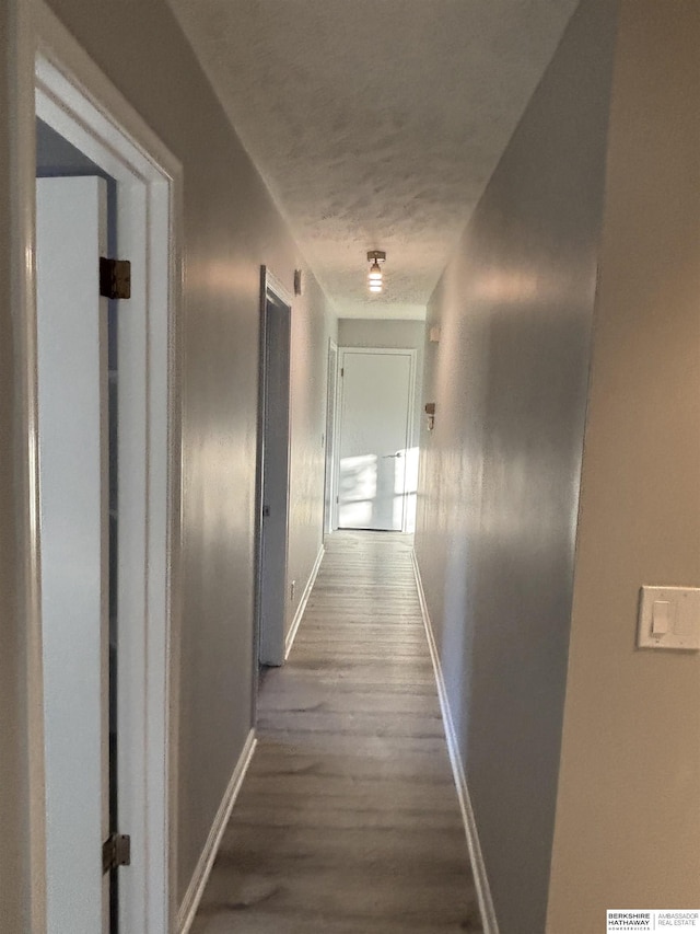 corridor featuring a textured ceiling and dark wood-type flooring