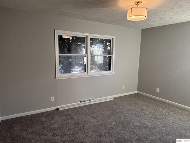 carpeted empty room with a textured ceiling