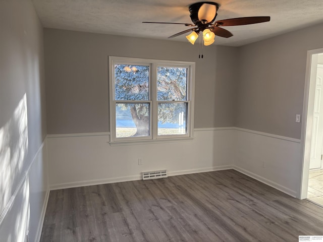 spare room with ceiling fan, hardwood / wood-style floors, and a wealth of natural light