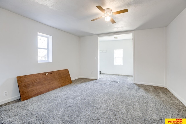 unfurnished room featuring ceiling fan, a textured ceiling, and carpet flooring