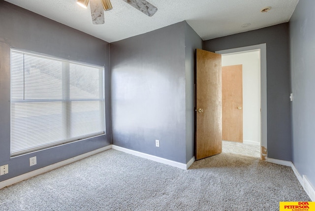 spare room featuring carpet flooring, a textured ceiling, and ceiling fan