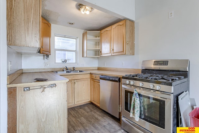 kitchen with appliances with stainless steel finishes, light hardwood / wood-style floors, light brown cabinetry, and sink