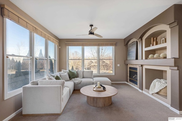 living room featuring carpet flooring, ceiling fan, and a wealth of natural light