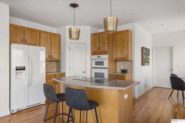 kitchen with white appliances, a center island, tasteful backsplash, and hanging light fixtures